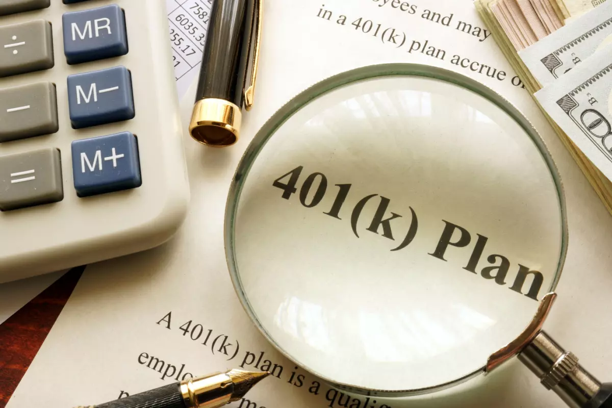 Close up on 401(k) plan paperwork and magnifying glass