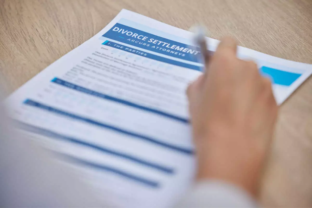 Close up on individual signing divorce paperwork