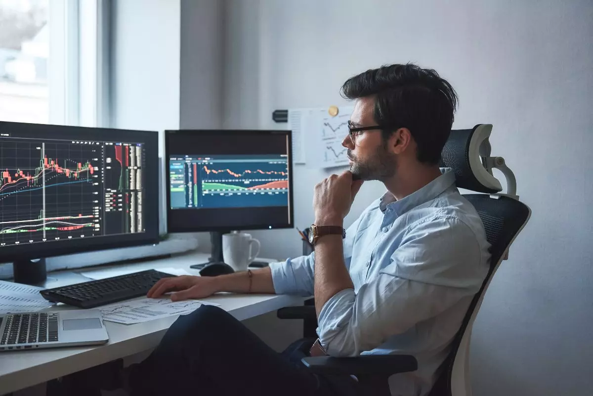 Young adult checking stocks on computer